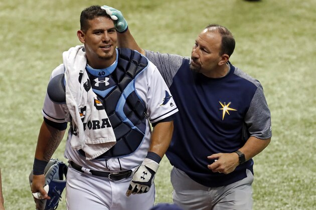 Tampa Bay Rays head athletic trainer Ron Porterfield, right, applies pressure to a cut on the head of Rays catcher Wilson Ramos who was struck by the broken bat of Baltimore Orioles' Ruben Tejada during the fifth inning of a baseball game Monday, July 24, 2017, in St. Petersburg, Fla. (AP Photo/Mike Carlson)