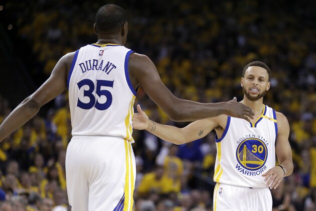 Golden State Warriors' Stephen Curry, right, shakes hands with teammate Kevin Durant (35) during the first half in Game 2 of an NBA basketball second-round playoff series against the Utah Jazz, Thursday, May 4, 2017, in Oakland, Calif. (AP Photo/Marcio Jose Sanchez)