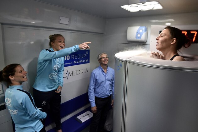 France's goalkeeper Celine Deville (R) stands in a medical device  used for cryotherapy next to defender Julie Soyer (C) at the the French national football team training base in Clairefontaine-en-Yvelines, on May 11, 2015 as part of the preparation for the upcoming FIFA 2015 World Cup. AFP PHOTO / FRANCK FIFE
-FRANCE OUT-        (Photo credit should read FRANCK FIFE/AFP/Getty Images)