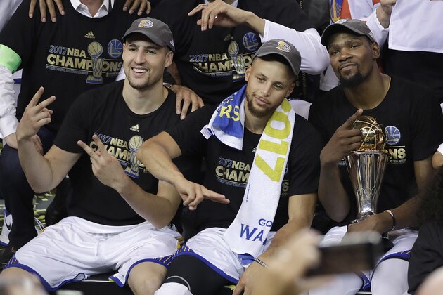 Golden State Warriors guard Klay Thompson, from left, guard Stephen Curry and forward Kevin Durant celebrate after Game 5 of basketball's NBA Finals against the Cleveland Cavaliers in Oakland, Calif., Monday, June 12, 2017. The Warriors won 129-120 to win the NBA championship. (AP Photo/Marcio Jose Sanchez)