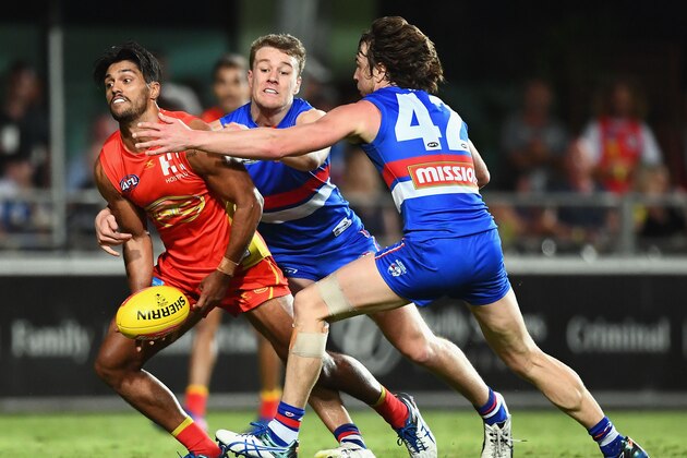 CAIRNS, AUSTRALIA - JULY 22: Aaron Hall of the Suns handballs whilst being tackled by Jackson Macrae and Liam Picken of the Bulldogs during the round 18 AFL match between the Western Bulldogs and the Gold Coast Suns at Cazaly's Stadium on July 22, 2017 in Cairns, Australia. (Photo by Quinn Rooney/Getty Images) CAIRNS, AUSTRALIA - JULY 22: Aaron Hall of the Suns handballs whilst being tackled by Jackson Macrae and Liam Picken of the Bulldogs during the round 18 AFL match between the Western Bulldogs and the Gold Coast Suns at Cazaly's Stadium on July 22, 2017 in Cairns, Australia. (Photo by Quinn Rooney/Getty Images)
