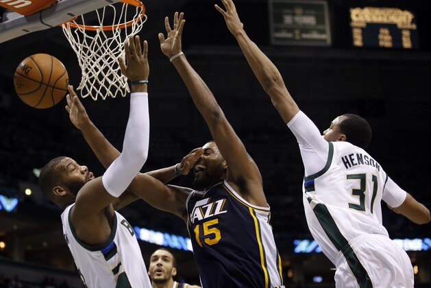 Utah Jazz's Derrick Favors tries to drive between Milwaukee Bucks' John Henson (31) and Greg Monroe during the second half of an NBA basketball game Sunday, March 20, 2016, in Milwaukee. (AP Photo/Morry Gash)