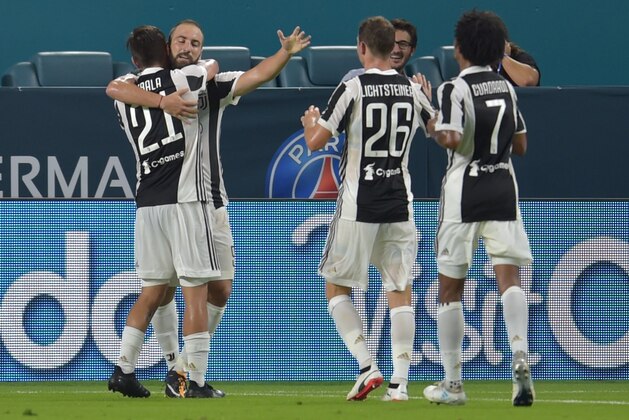 Gonzalo Higuaín (2nd-L) of Juventus is embraced by teammate Paulo Dybala (L) after scoring a goal against Paris Saint-Germain during their International Champions Cup friendly match at Hard Rock Stadium in Miami, Florida, on July 25, 2017. / AFP PHOTO / Hector RETAMAL        (Photo credit should read HECTOR RETAMAL/AFP/Getty Images)