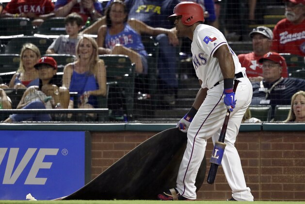 Texas Rangers' Adrian Beltre drags the on deck circle toward himself after being told by tje home plate umpire to get back to the circle during a Nomar Mazara at-bat in the eighth inning of a baseball game against the Miami Marlins on Wednesday, July 26, 2017, in Arlington, Texas. Crew chief Gerry Davis ejected Beltre after that action in the 22-10 Mariners' win. (AP Photo/Tony Gutierrez)