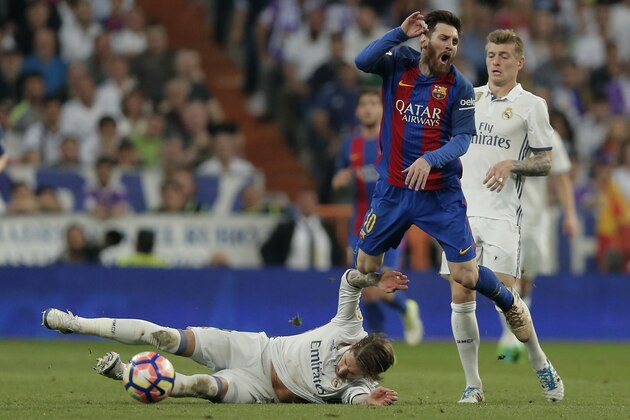 Barcelona's Lionel Messi is fouled by Real Madrid's Sergio Ramos during a Spanish La Liga soccer match between Real Madrid and Barcelona, dubbed 'el clasico', at the Santiago Bernabeu stadium in Madrid, Spain, Sunday, April 23, 2017. (AP Photo/Daniel Ochoa de Olza)
