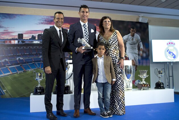 MADRID, SPAIN - OCTOBER 02:  Cristiano Ronaldo (2ndL) poses for a picture with his trophy as all-time top scorer of of Real Madrid CF with his son Cristiano Ronald JR, mother Maria Dolores dos Santos and his manager Jorge Mendes (L) at Honour box-seat of Santiago Bernabeu  Stadium on October 2, 2015 in Madrid, Spain. Portuguese palyer Cristiano Ronaldo overtook on his last UEFA Champions League match against Malmo FF Raul's  record as Real Madrid all-time top scorer.  (Photo by Gonzalo Arroyo Moreno/Getty Images)