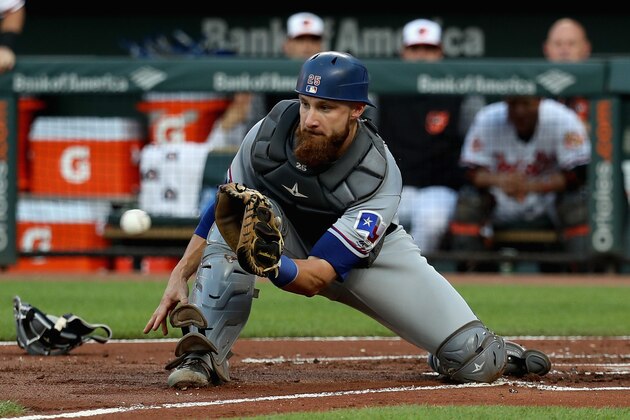 BALTIMORE, MD - JULY 18:  Catcher Jonathan Lucroy #25 of the Texas Rangers catches the ball at the plate as the Baltimore Orioles scored two runs in the first inning at Oriole Park at Camden Yards on July 18, 2017 in Baltimore, Maryland.  (Photo by Rob Carr/Getty Images)