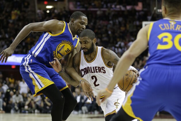 Cleveland Cavaliers guard Kyrie Irving (2) drives between Golden State Warriors forward Kevin Durant (35) and Stephen Curry (30) during the second half of Game 3 of basketball's NBA Finals in Cleveland, Wednesday, June 7, 2017. Golden State won 118-113 (AP Photo/Tony Dejak)