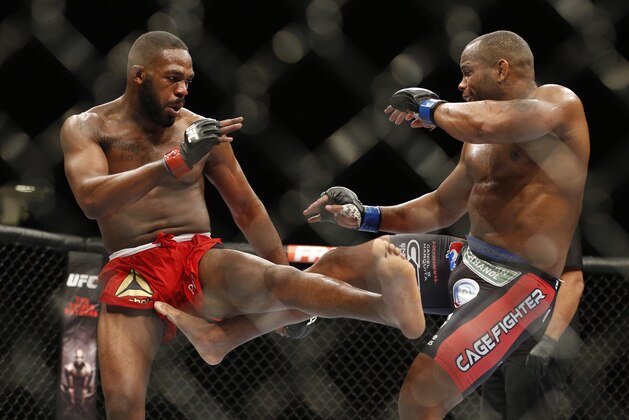 FILE - In this Jan. 3, 2015 file photo, Daniel Cormier, right, kicks Jon Jones during their light heavyweight title mixed martial arts bout at UFC 182, in Las Vegas. UFC is replacing its canceled Conor McGregor fight for another rematch, Jon Jones vs. Daniel Cormier for the light heavyweight title at UFC 200. UFC officials announced the replacement main event on Wednesday, April 27, 2016, several days after Jones beat Ovince Saint Preux by decision in his first fight since he had his title stripped in 2015.(AP Photo/John Locher, File)