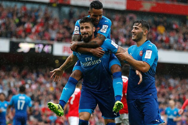 Arsenal's French striker Olivier Giroud celebrates with Arsenal's English midfielder Theo Walcott (up) and Arsenal's German-born Bosnian defender Sead Kolasinac (R) after scoring their fouth goal during the pre-season friendly football match between Arsenal and Benfica at The Emirates Stadium in north London on July 29, 2017, the game is one of four matches played over two days for the Emirates Cup. / AFP PHOTO / Ian KINGTON / RESTRICTED TO EDITORIAL USE. No use with unauthorized audio, video, data, fixture lists, club/league logos or 'live' services. Online in-match use limited to 75 images, no video emulation. No use in betting, games or single club/league/player publications.  /         (Photo credit should read IAN KINGTON/AFP/Getty Images)