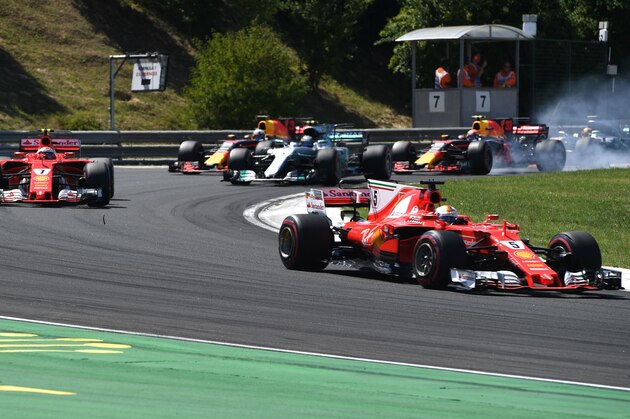 Ferrari's German driver Sebastian Vettel (R), Ferrari's Finnish driver Kimi Raikkonen (L) and other pilots race at the Hungaroring circuit in Budapest on July 30, 2017, during the Formula One Hungarian Grand Prix. / AFP PHOTO / Andrej ISAKOVIC        (Photo credit should read ANDREJ ISAKOVIC/AFP/Getty Images)