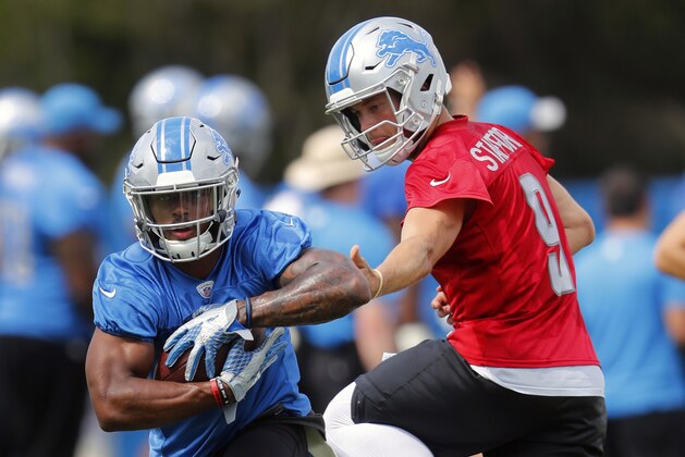 Detroit Lions quarterback Matthew Stafford (9) hands off to running back Ameer Abdullah (21) during NFL football training camp in Allen Park, Mich., Sunday, July 30, 2017. (AP Photo/Paul Sancya)