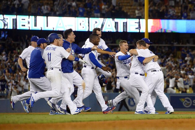 Los Angeles Dodgers' Kyle Farmer, second from right, celebrates with teammates after hitting a two-RBI double win in the 11th inning of a baseball game against the San Francisco Giants, Sunday, July 30, 2017, in Los Angeles. (AP Photo/Mark J. Terrill)