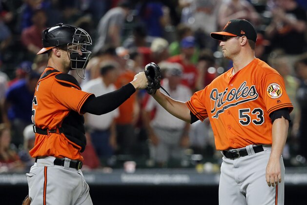 Baltimore Orioles' Caleb Joseph celebrates with relief pitcher Zach Britton (53) after their win over the Texas Rangers in a baseball game, Saturday, July 29, 2017, in Arlington, Texas. (AP Photo/Tony Gutierrez)