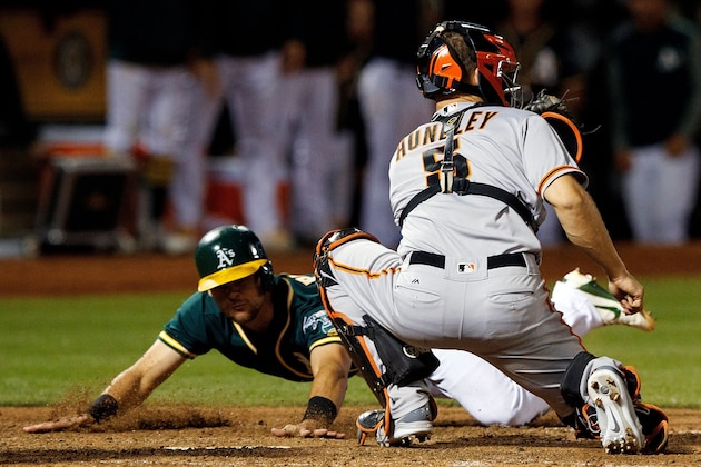 OAKLAND, CA - JULY 31:  Chad Pinder #18 of the Oakland Athletics dives into home plate to score a run ahead of a tag from Nick Hundley #5 of the San Francisco Giants during the eighth inning at the Oakland Coliseum on July 31, 2017 in Oakland, California. The Oakland Athletics defeated the San Francisco Giants 8-5. (Photo by Jason O. Watson/Getty Images)