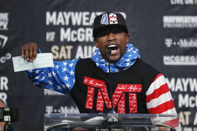 Floyd Mayweather Jr. holds up a check while speaking at a news conference at Staples Center Tuesday, July 11, 2017, in Los Angeles. Mayweather Jr. is scheduled to fight Conor McGregor in a boxing match in Las Vegas on Aug. 26. (AP Photo/Jae C. Hong) Floyd Mayweather Jr. holds up a check while speaking at a news conference at Staples Center Tuesday, July 11, 2017, in Los Angeles. Mayweather Jr. is scheduled to fight Conor McGregor in a boxing match in Las Vegas on Aug. 26. (AP Photo/Jae C. Hong)