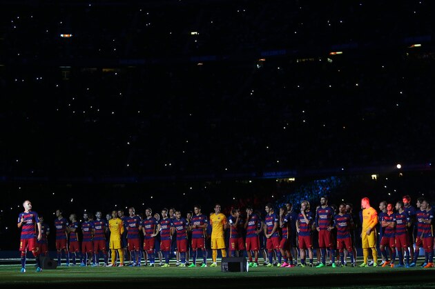 Barcelona's Andres Iniesta, left, addresses the supporters during the presentation of the team for the new season moments before the Joan Gamper trophy soccer match between FC Barcelona and AS Roma at the Camp Nou stadium in Barcelona, Spain, Wednesday, Aug. 5, 2015. (AP Photo/Francisco Seco)