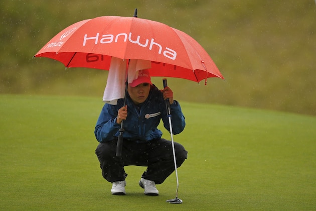 Korea's In-Kyung Kim reacts shelters under an umbrella as she lines up her putt on the 18th green during her second round on day 2 of the 2017 Women's British Open Golf Championship at Kingsbarns Golf Links near St. Andrews, east Scotland, on August 4, 2017. / AFP PHOTO / Andy BUCHANAN (Photo credit should read ANDY BUCHANAN/AFP/Getty Images) Korea's In-Kyung Kim reacts shelters under an umbrella as she lines up her putt on the 18th green during her second round on day 2 of the 2017 Women's British Open Golf Championship at Kingsbarns Golf Links near St. Andrews, east Scotland, on August 4, 2017. / AFP PHOTO / Andy BUCHANAN (Photo credit should read ANDY BUCHANAN/AFP/Getty Images)