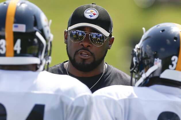 Pittsburgh Steelers head coach Mike Tomlin, center, talks with running backs Knile Davis (34), and Brandon Dixon during practice at NFL football training camp in Latrobe, Pa., Sunday, July 30, 2017 . (AP Photo/Keith Srakocic)
