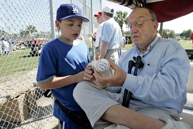 Former Major League Baseball Commissioner Fay Vincent signs an autograph for Louis Carrons, 12, of Rancho Cucamonga, Calif., during Los Angeles Dodgers baseball spring training in Vero Beach, Fla.,  Wednesday March 1, 2006. (AP Photo/Richard Drew)