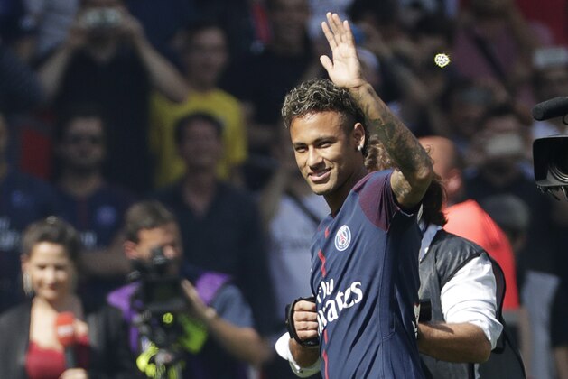Paris Saint-Germain's Brazilian forward Neymar waves to the crowd as he arrives on the football field during his presentation to the fans at the Parc des Princes stadium in Paris, on August 5, 2017.
Brazil superstar Neymar will watch from the stands as Paris Saint-Germain open their season on August 5, 2017, but the French club have already clawed back around a million euros on their world record investment. Neymar, who signed from Barcelona for a mind-boggling 222 million euros ($264 million), is presented to the PSG support prior to his new team's first game of the Ligue 1 campaign against promoted Amiens.
 / AFP PHOTO / Thomas Samson        (Photo credit should read THOMAS SAMSON/AFP/Getty Images)