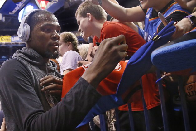 Golden State Warriors forward Kevin Durant gives autographs to fans before an NBA basketball game against the Oklahoma City Thunder in Oklahoma City, Saturday, Feb. 11, 2017. (AP Photo/Sue Ogrocki)