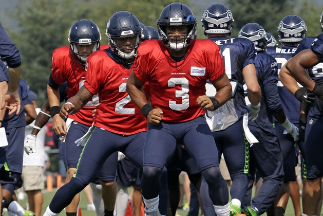 Seattle Seahawks' Russell Wilson (3) leads fellow quarterbacks Trevone Boykin (2) and Austin Davis through drills during an NFL football training camp Friday, Aug. 4, 2017, in Renton, Wash. (AP Photo/Elaine Thompson)