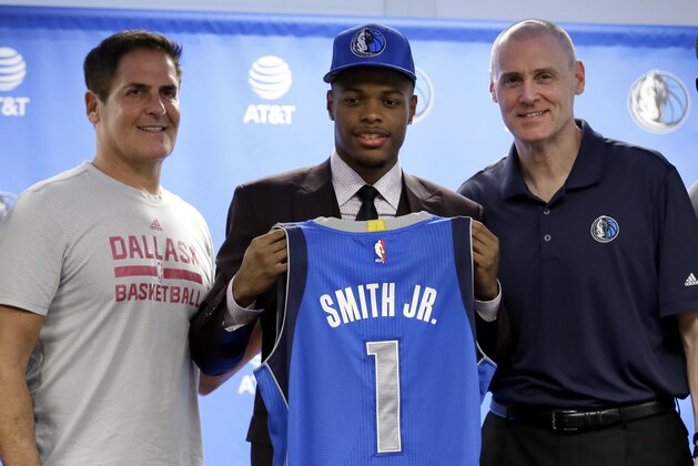 Dallas Mavericks team owner Mark Cuban, left, and head coach Rick Carlisle, right, present their NBA basketball first-round draft selection, Dennis Smith Jr., center, with his team jersey during a news conference, Friday, June 23, 2017, in Dallas. (AP Photo/Tony Gutierrez)