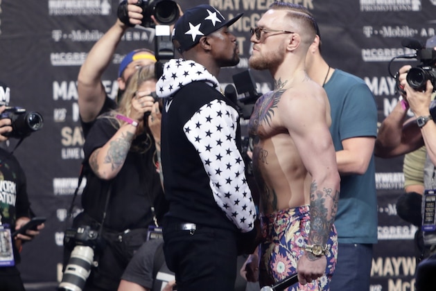 This July 13, 2017 photo shows Floyd Mayweather Jr., left, and Conor McGregor, of Ireland, facing each other for photos during a news conference at Barclays Center in New York. So far fans aren't exactly storming the box office to buy tickets for Mayweather Jr.'s fight next month with McGregor. A check online Saturday, July 29, 2017 revealed hundreds _ even thousands _ of seats still available from Ticketmaster at the T-Mobile arena for the Aug. 26 fight. There are so many open seats that fans with enough room left on their credit cards can buy six tickets together in 162 different spots throughout the arena. (AP Photo/Frank Franklin II)