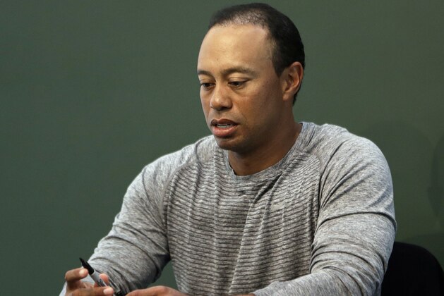 Golfer Tiger Woods prepares to sign copies of his new book at a book signing in New York, Monday, March 20, 2017. (AP Photo/Seth Wenig)