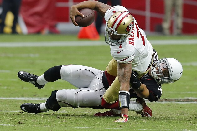 San Francisco 49ers quarterback Colin Kaepernick (7) gets tackled by Arizona Cardinals free safety Tyrann Mathieu (32) during the first half of an NFL football game, Sunday, Sept. 21, 2014, in Glendale, Ariz. (AP Photo/Rick Scuteri)