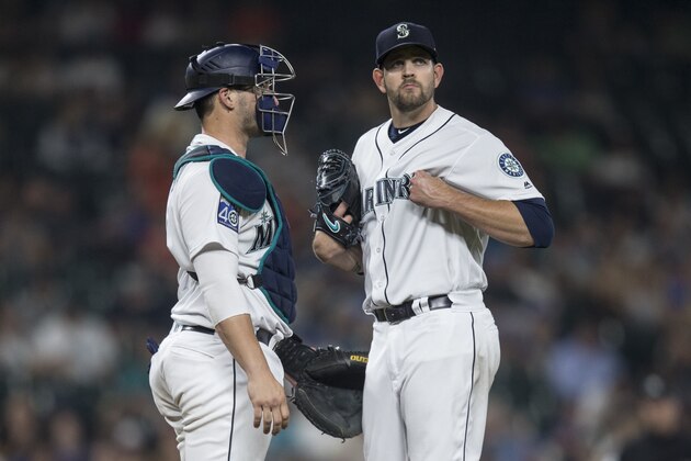 SEATTLE, WA - AUGUST 10: Starting pitcher James Paxton #65 of the Seattle Mariners grabs his jersey while meeting at the pitcher's mound with catcher Mike Zunino #3 of the Seattle Mariners shortly before Paxton left with a left pectoral strain during the sixth inning of a game against the Los Angeles Angels of Anaheim at Safeco Field on August 10, 2017 in Seattle, Washington. The Angels won the game 6-3. (Photo by Stephen Brashear/Getty Images)