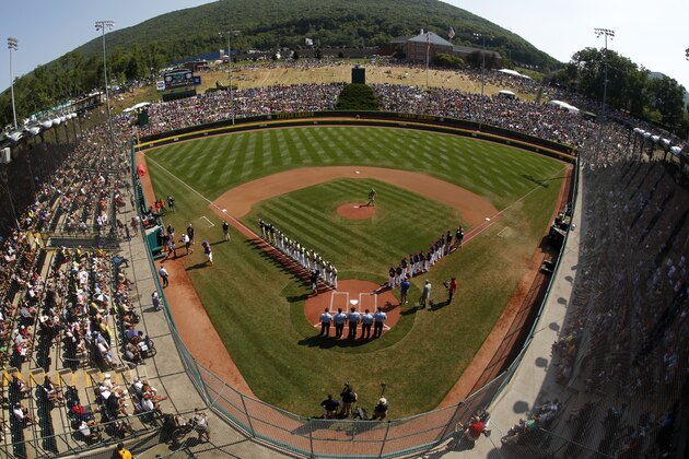FILE - In this Aug. 28, 2016, file photo, taken with a fisheye lens, South Korea lines the third baseline and Endwell, N.Y. lines the first baseline during team introductions before the Little League World Series Championship baseball game at Lamade Stadium in South Williamsport, Pa. Little League International announced mandatory criminal background checks for its volunteer coaches, new eligibility requirements for players and a host of new rules on Wednesday, Jan. 4, 2017, intended to increase the pace of play. (AP Photo/Gene J. Puskar, File) FILE - In this Aug. 28, 2016, file photo, taken with a fisheye lens, South Korea lines the third baseline and Endwell, N.Y. lines the first baseline during team introductions before the Little League World Series Championship baseball game at Lamade Stadium in South Williamsport, Pa. Little League International announced mandatory criminal background checks for its volunteer coaches, new eligibility requirements for players and a host of new rules on Wednesday, Jan. 4, 2017, intended to increase the pace of play. (AP Photo/Gene J. Puskar, File)