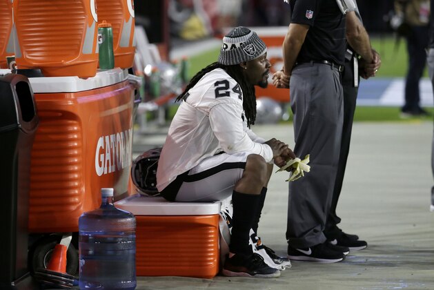 Oakland Raiders running back Marshawn Lynch (24) sits during the national anthem prior to an NFL preseason football game against the Arizona Cardinals, Saturday, Aug. 12, 2017, in Glendale, Ariz. (AP Photo/Rick Scuteri)
