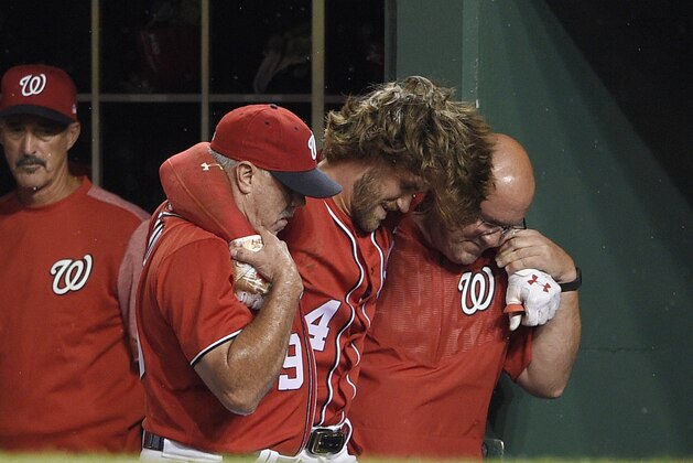Washington Nationals' Bryce Harper, center, is helped in the dugout after he was injured during the first inning of the team's baseball game against the San Francisco Giants, Saturday, Aug. 12, 2017, in Washington. (AP Photo/Nick Wass) Washington Nationals' Bryce Harper, center, is helped in the dugout after he was injured during the first inning of the team's baseball game against the San Francisco Giants, Saturday, Aug. 12, 2017, in Washington. (AP Photo/Nick Wass)