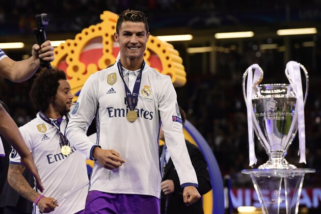 TOPSHOT - Real Madrid's Portuguese striker Cristiano Ronaldo celebrates next to the trophy after Real Madrid won the UEFA Champions League final football match between Juventus and Real Madrid at The Principality Stadium in Cardiff, south Wales, on June 3, 2017. / AFP PHOTO / JAVIER SORIANO        (Photo credit should read JAVIER SORIANO/AFP/Getty Images)