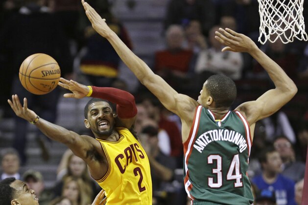 Milwaukee Bucks' Giannis Antetokounmpo (34), from Greece, puts pressure on Cleveland Cavaliers' Kyrie Irving (2) during an NBA basketball game Wednesday, Dec. 31, 2014, in Cleveland. (AP Photo/Tony Dejak)