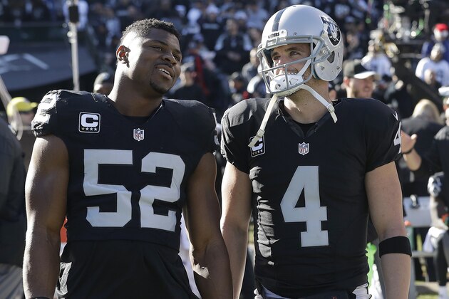 Oakland Raiders defensive end Khalil Mack (52) and quarterback Derek Carr (4) before an NFL football game against the Indianapolis Colts in Oakland, Calif., Saturday, Dec. 24, 2016. (AP Photo/Marcio Jose Sanchez)