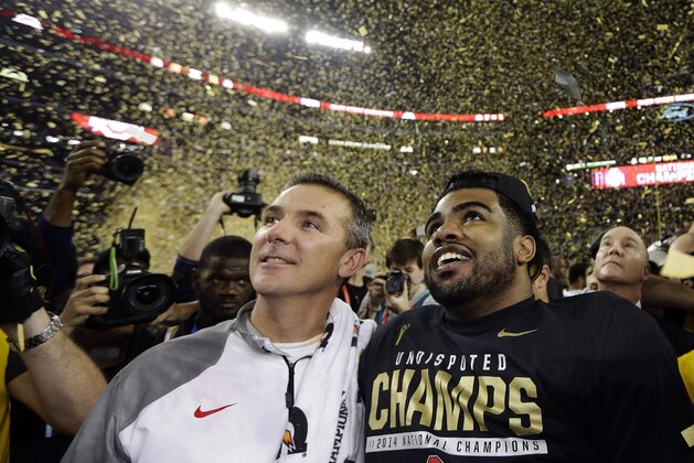 FILE - In this Jan. 12, 2015, file photo, Ohio State head coach Urban Meyer, left, and Ezekiel Elliott celebrate after they defeated Oregon 42-20 in the NCAA college football playoff championship game in Arlington, Texas. Elliott apologized for the critical comments he made about play calling after the Michigan State game and says it was the wrong time to make it known he would not be returning to school next season. Elliott posted a long apology on Twitter on Monday, Nov. 23, 2015,  saying,