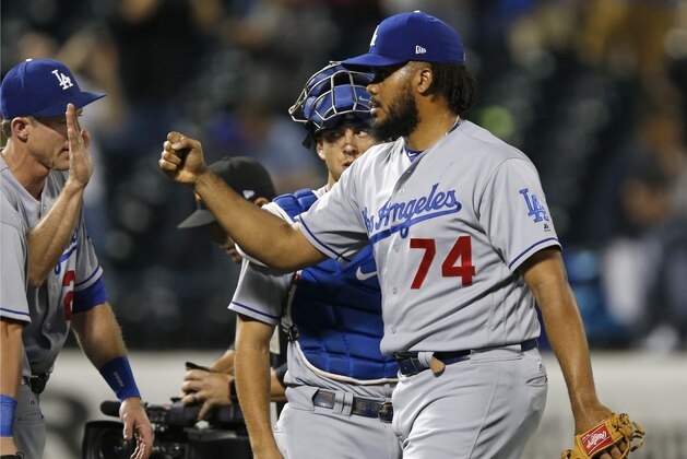Los Angeles Dodgers relief pitcher Kenley Jansen (74) is congratulated as he and Los Angeles Dodgers catcher Austin Barnes, center, leave the field after the Dodgers 8-0 shutout of the New York Mets in a baseball game Sunday, Aug. 6, 2017, in New York. (AP Photo/Kathy Willens)