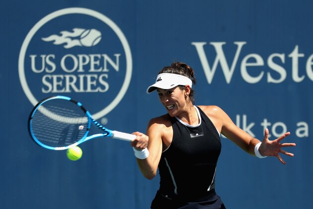 MASON, OH - AUGUST 18:  Garbine Muguruza of Spain returns a shot to Svetlana Kuznetsova of Russia during Day 7 of the Western and Southern Open at the Linder Family Tennis Center on August 18, 2017 in Mason, Ohio.  (Photo by Rob Carr/Getty Images)