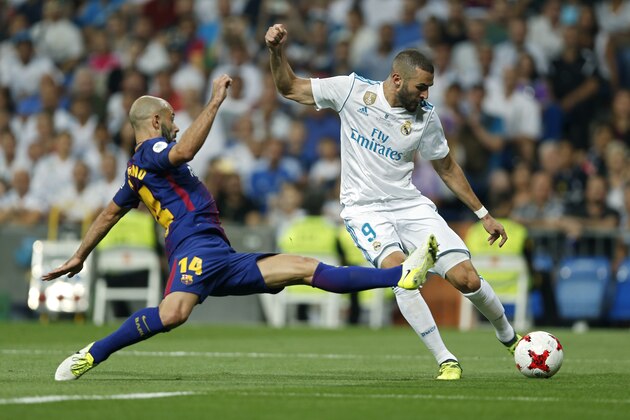 Real Madrid's Karim Benzema, right, vies for the ball with Barcelona's Javier Mascherano during the Spanish Super Cup second leg soccer match between Real Madrid and Barcelona at the Santiago Bernabeu Stadium in Madrid, Thursday, Aug. 17, 2017. Benzema scored once and Real Madrid won 5-1 on aggregate. (AP Photo/Francisco Seco)