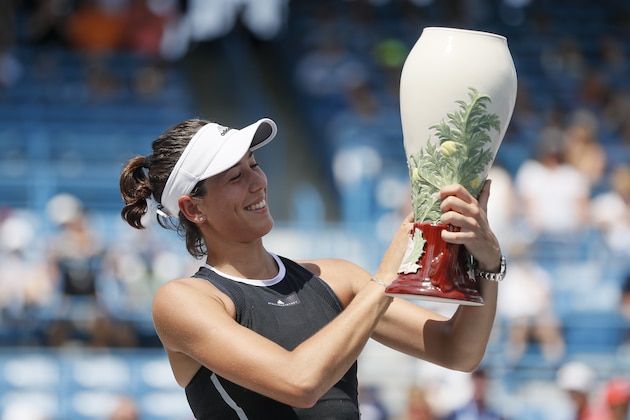Garbine Muguruza, of Spain, holds the Rookwood Cup after defeating Simona Halep, of Romania, in the women's singles final at the Western & Southern Open, Sunday, Aug. 20, 2017, in Mason, Ohio. Muguruza won 6-1, 6-0. (AP Photo/John Minchillo)
