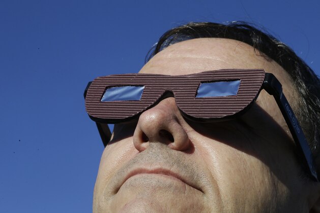Lee Cooper, from England, wears his protective glasses to watch the beginning of the solar eclipse from Salem, Ore., Monday, Aug. 21, 2017. (AP Photo/Don Ryan)
