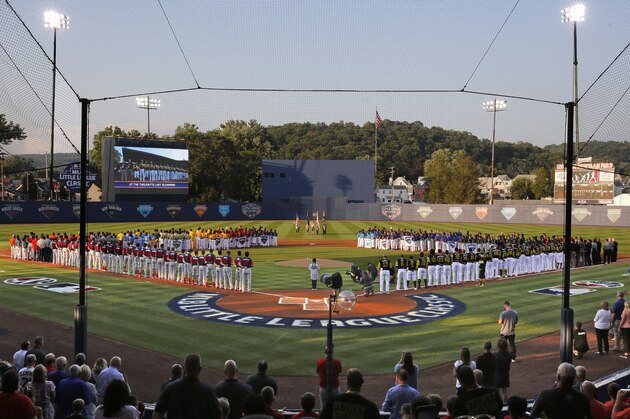 The Pittsburgh Pirates and St. Louis Cardinals line the baselines, and the 16 Little League teams from around the world participating in the Little League World Series line the infield before the Little League Classic baseball game between the Pirates and the Cardinals at Bowman Field in Williamsport, Pa., Sunday, Aug. 20, 2017. (AP Photo/Gene J. Puskar)