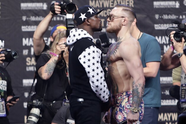 In this July 13, 2017, file photo, Floyd Mayweather Jr., left, and Conor McGregor, of Ireland, face each other for photos during a news conference at Barclays Center in New York. Nevada boxing regulators went out of their way to give a gift to both fighters, approving an exemption to the rule requiring 10-ounce gloves for the 154-pound fight so that both fighters can wear 8-ounce gloves. And just like that, the fight appeared more competitive–at least to some. (AP Photo/Frank Franklin II, File)