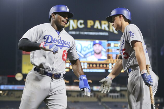 Los Angeles Dodgers' Yasiel Puig, left, is greeted by on-deck batter Corey Seager after scoring from third on a hit by Chris Taylor in the fourth inning of a baseball game against the Pittsburgh Pirates, Tuesday, Aug. 22, 2017, in Pittsburgh. (AP Photo/Keith Srakocic)