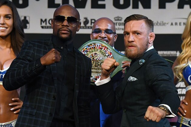 LAS VEGAS, NV - AUGUST 23:  Boxer Floyd Mayweather Jr. (L) and UFC lightweight champion Conor McGregor (R) pose as Mayweather Promotions CEO Leonard Ellerbe (C) looks on during a news conference at the KA Theatre at MGM Grand Hotel & Casino on August 23, 2017 in Las Vegas, Nevada. Mayweather and McGregor will meet in a super welterweight boxing match at T-Mobile Arena on August 26 in Las Vegas.  (Photo by Ethan Miller/Getty Images)