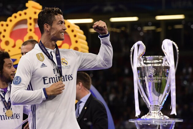 Real Madrid's Portuguese striker Cristiano Ronaldo celebrates next to the trophy after Real Madrid won the UEFA Champions League final football match between Juventus and Real Madrid at The Principality Stadium in Cardiff, south Wales, on June 3, 2017. / AFP PHOTO / JAVIER SORIANO        (Photo credit should read JAVIER SORIANO/AFP/Getty Images)