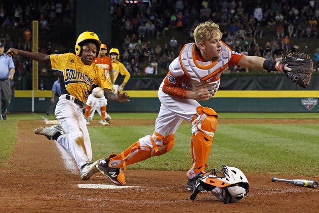 Lufkin, Texas, catcher Chandler Spencer, right, can't handle the throw from first baseman Mark Requena, allowing Greenville, N.C.'s Cash Daniels-Moye to score the winning run on a ball hit by Thomas Barrett during the seventh inning of a baseball game at the Little League World Series in South Williamsport, Pa., Wednesday, Aug. 23, 2017. North Carolina won 2-1. (AP Photo/Gene J. Puskar)
